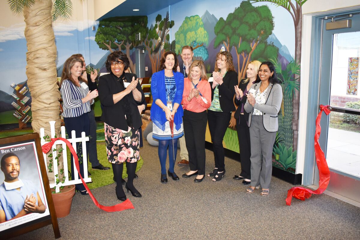 Ginger Couvrette, Candy Carson, Principal Gail West, T.J. Zane, Katie MacLeod, Michelle O'Connor-Ratcliff, Jennifer Burks and Darshana Patel cut the ribbon for the new reading room.
