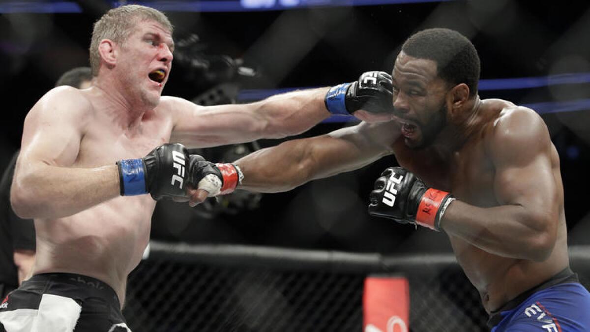 Daniel Kelly, left, and Rashad Evans trade blows during their UFC 209 fight.