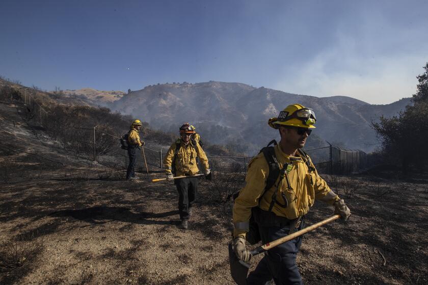 PORTER RANCH, CALIF. -- FRIDAY, OCTOBER 11, 2019: LA city brush crew heads out to clears fuel behind homes on Via Urbino as firefighters battle the Saddleridge fire in Porter Ranch, Calif., on Oct. 11, 2019. (Brian van der Brug / Los Angeles Times)