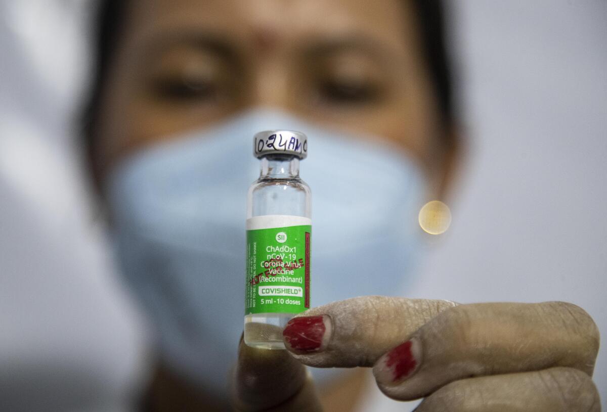 FILE - In this Monday, March 1, 2021, file photo, a health worker displays the AstraZeneca COVID-19 vaccine, manufactured by the Serum Institute of India before administering it to an elderly person in Gauhati, India. The world's largest vaccine maker, based in India, will be able to restart exports of AstraZeneca doses by June if new coronavirus infections subside in the country, its chief executive said Tuesday, April 6. India initially immunized the most vulnerable, but broadened that to everyone over 45 on April 1 because of the surge in cases. The resulting increased demand forced the halt in exports. (AP Photo/Anupam Nath)