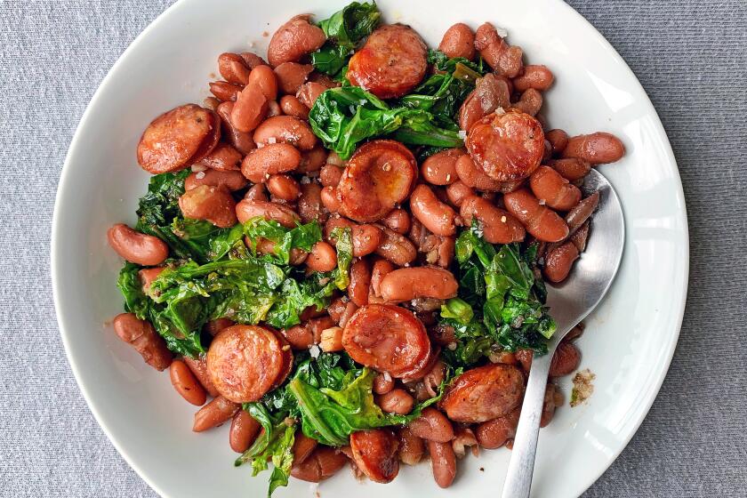 Spicy, brick-red andouille sausage flavors both red kidney beans and sautéed young mustard greens in this comforting one-pot dish.