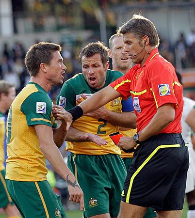 Referee Roberto Rosetti pushes away Australia's Harry Kewell after showing him a red card during Australia's match against Ghana on Saturday. Ghana and Australia played to a 1-1 draw.