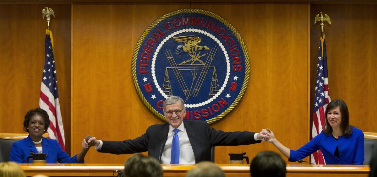 Federal Communication Commission Chairman Tom Wheeler, center, joins hands with FCC Commissioners Mignon Clyburn, left, and Jessica Rosenworcel before the start of a meeting at which they approved new net neutrality rules in 2015.