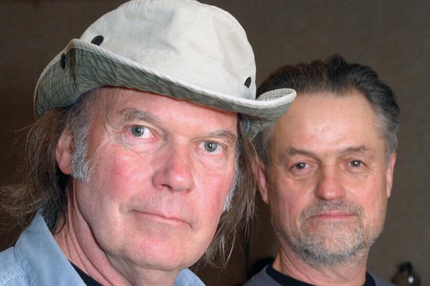 Musician Neil Young, left, and director Jonathan Demme, posing in Austin, Texas, at the South by Southwest music festival Thursday, March 16, 2006, worked together to make the new concert film "Neil Young-Heart of Gold."(AP Photo/Jack Plunkett) ORG XMIT: NYET167