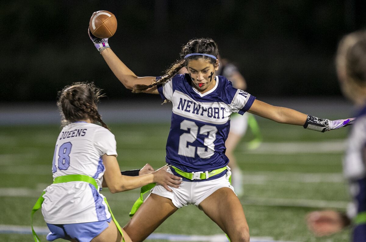 Newport Harbor's Maia Helmar attempts to avoid having her flag pulled by Corona del Mar's Abby Schalow.
