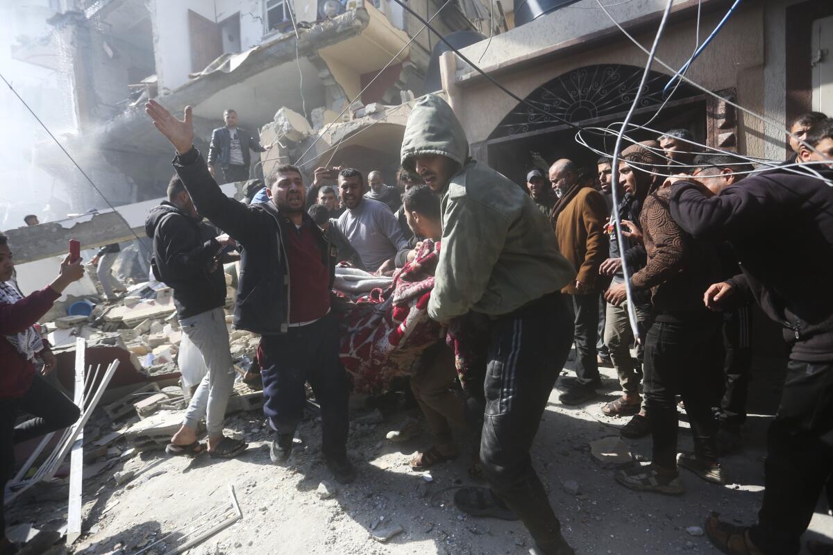 Palestinians rescue survivors after an Israeli strike on a house in Rafah in the Gaza Strip on Feb. 24. 