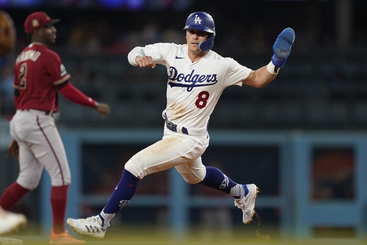 Dodgers' Kiké Hernández runs to second on a grounder hit by James Outman.