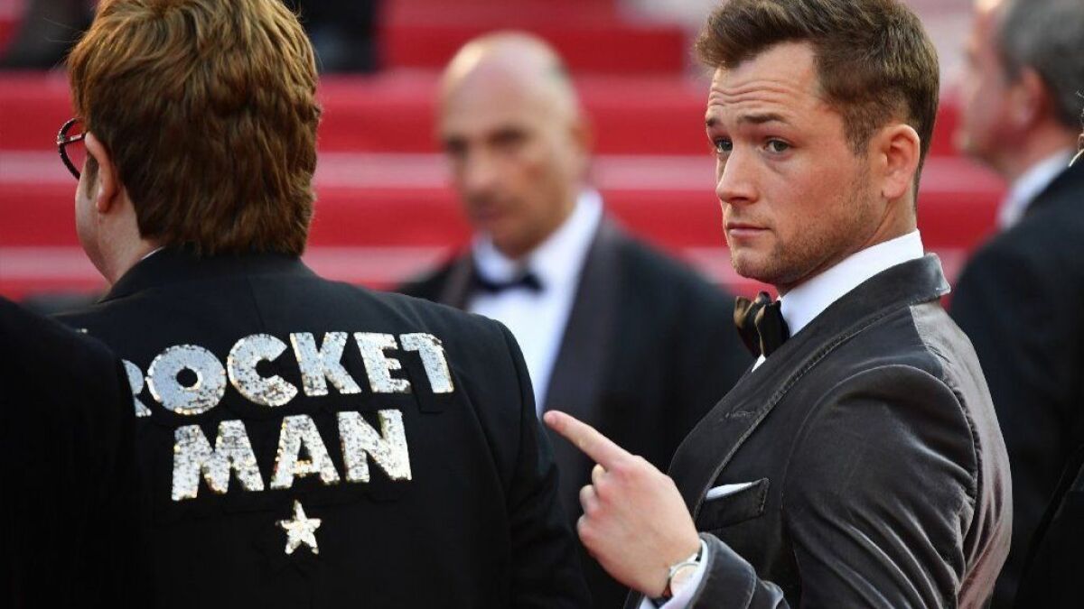 Actor Taron Egerton, right, points out the jacket of singer-songwriter Elton John as they arrive for the screening of the film "Rocketman" at the Cannes Film Festival.