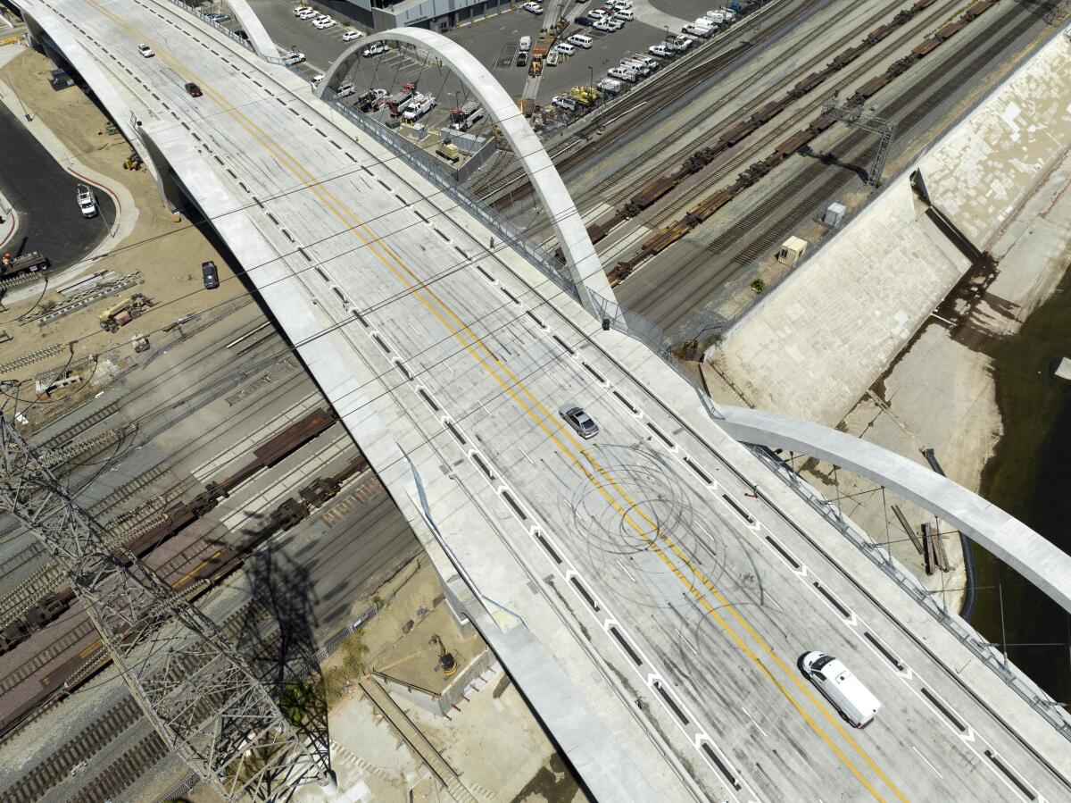 Aerial view of a bridge with tire marks in straight lines and loops on the street.