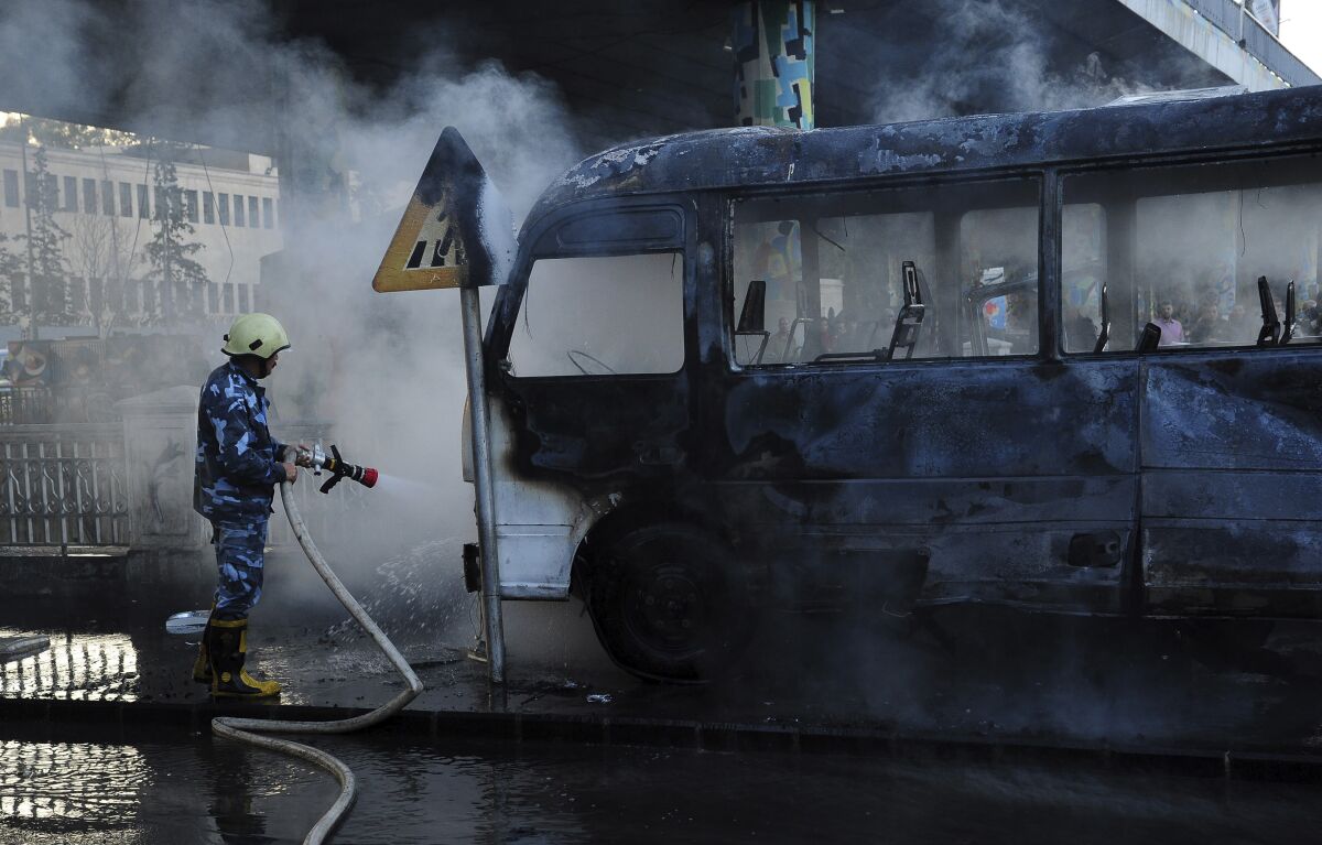 Firefighter spraying scorched bus