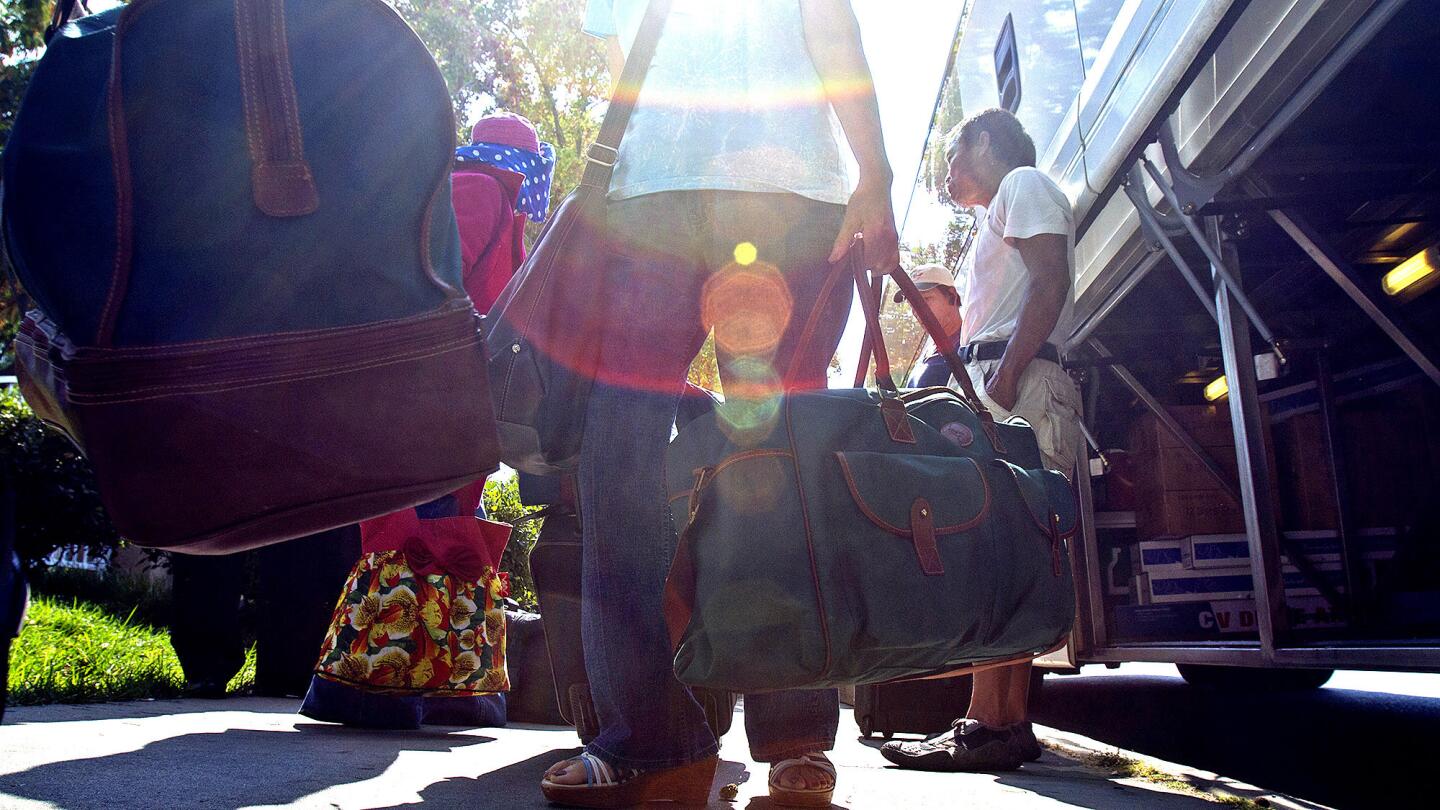 Travelers carry their bags after arriving in San Jose from Westminster. The line's owner, Linh Hoang Nguyen, stumbled onto the idea of connecting the two cities while waiting for a flight at John Wayne Airport. He now has a fleet of 11 buses and 15 drivers.