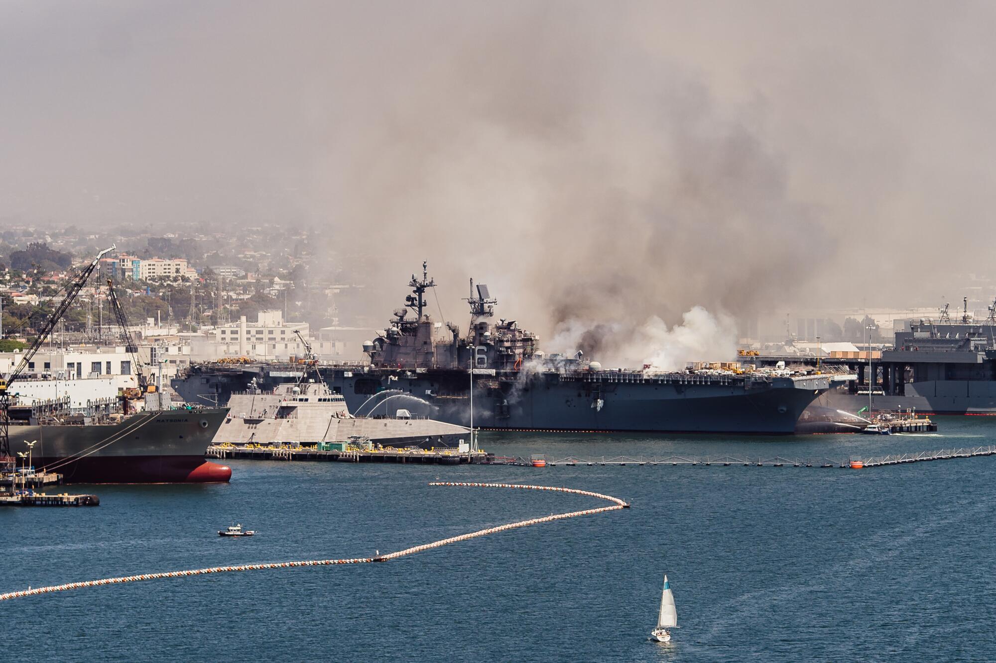 As seen from the Coronado bridge, emergency crews respond to the scene of a fire aboard the USS Bonhomme Richard.