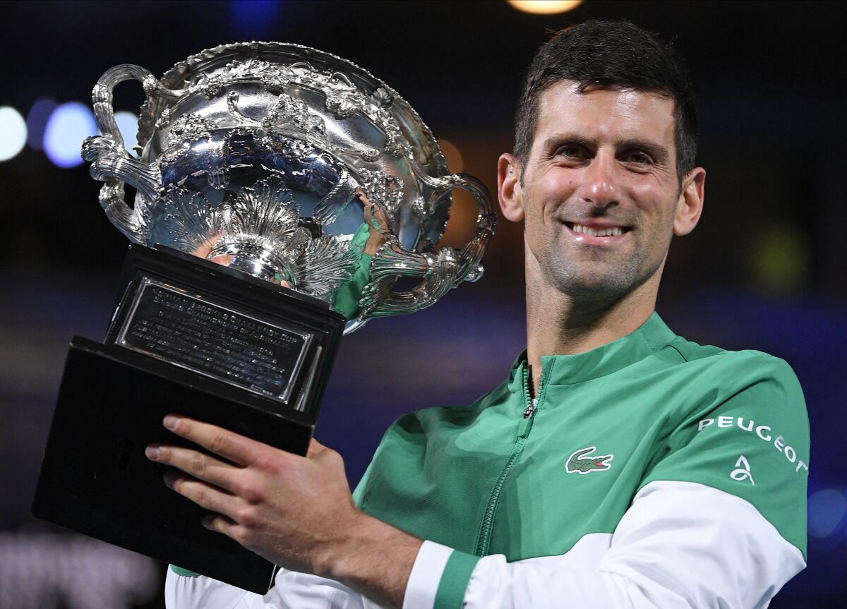 FILE - Serbia's Novak Djokovic holds the Norman Brookes Challenge Cup after defeating Russia's Daniil Medvedev in the men's singles final at the Australian Open tennis championship in Melbourne, Australia, Sunday, Feb. 21, 2021. Djokovic has had his visa canceled and been denied entry to Australia, Thursday, Jan. 6, 2022 and is set to be removed from the country after spending the night at the Melbourne airport as officials refused to let him enter the country for the Australian Open after an apparent visa mix-up.(AP Photo/Andy Brownbill, File)