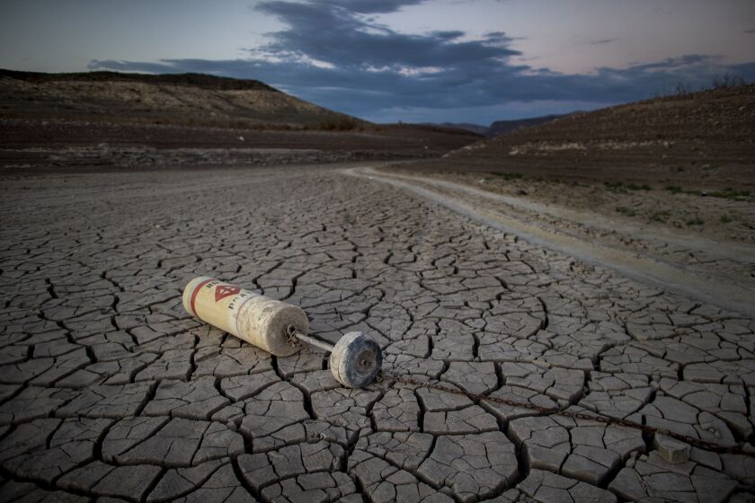 LAS VEGAS, NV -JULY 12, 2022: A buoy lays on a dried mud flat at a shuttered marina at the drought stricken Lake Mead on July 12, 2022 in Las Vegas, Nevada. The water levels at Lake Mead are at historic lows forcing the closures of all but one marina at the lake.(Gina Ferazzi / Los Angeles Times)