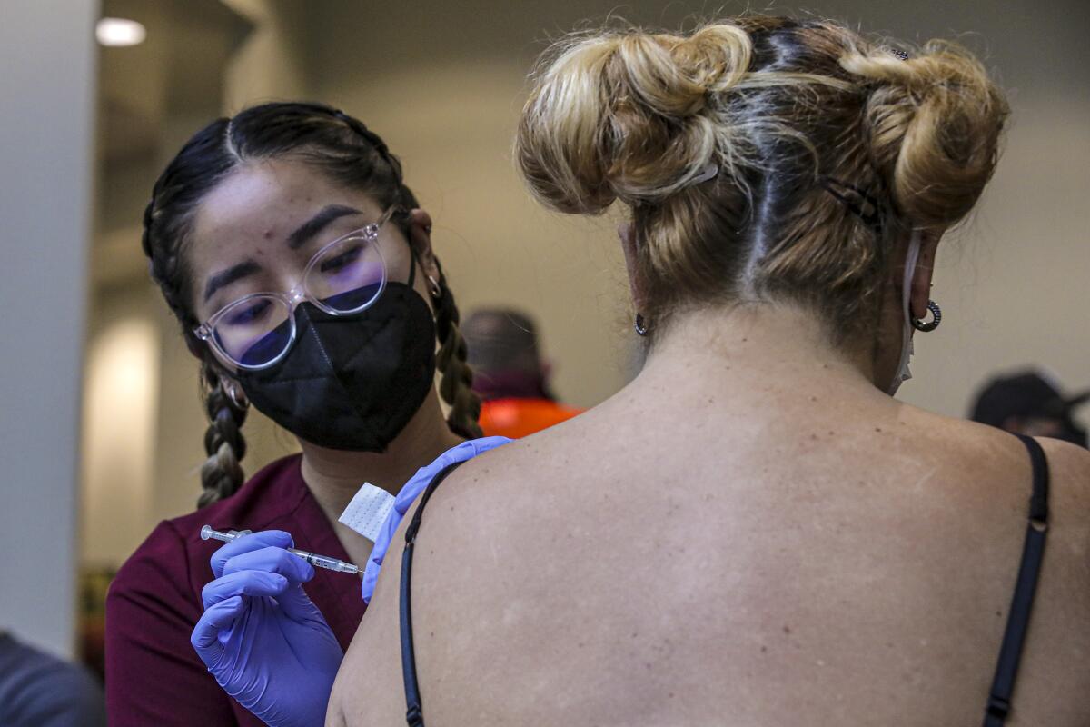 Thao Ngo administers a COVID-18 vaccine to a patient. 