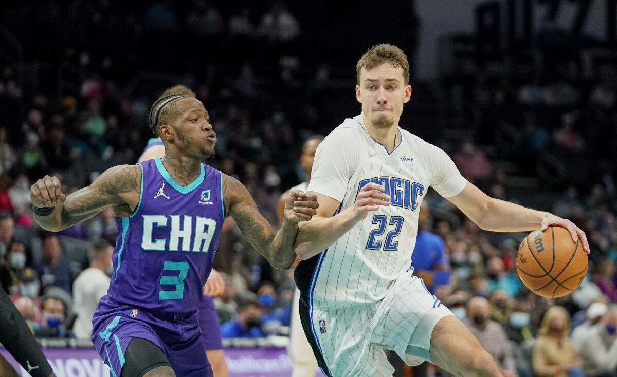 Orlando Magic forward Franz Wagner (22) drives in past Charlotte Hornets guard Terry Rozier (3) during the first half of an NBA basketball game on Friday, Jan. 14, 2022, in Charlotte, N.C. (AP Photo/Rusty Jones)