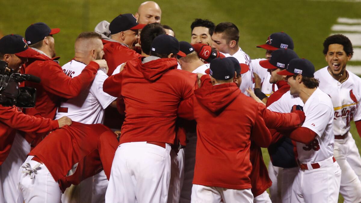 St. Louis Cardinals players celebrate with teammate Kolten Wong following his winning home run in the ninth inning of a 5-4 win over the San Francisco Giants in Game 2 of the National League Championship Series on Sunday.