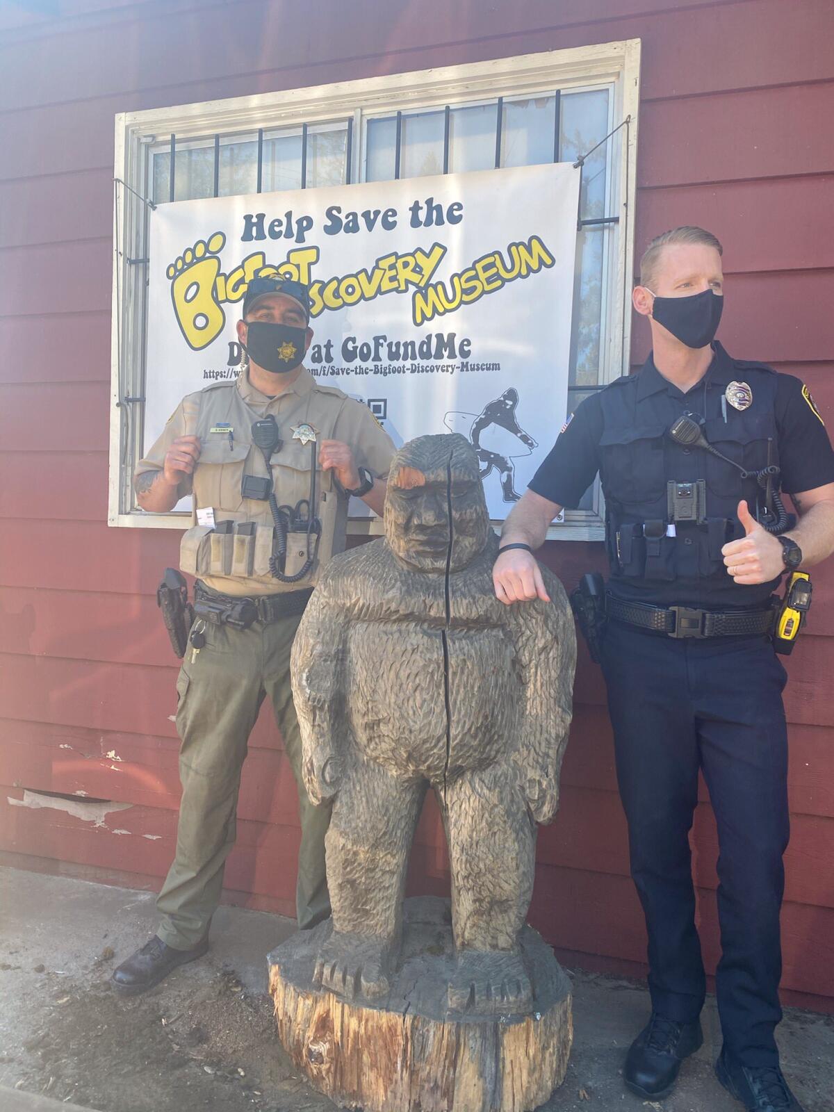 A Santa Cruz County Sheriff's Office deputy and a Scotts Valley Police Department officer pose next to Bigfoot statue.