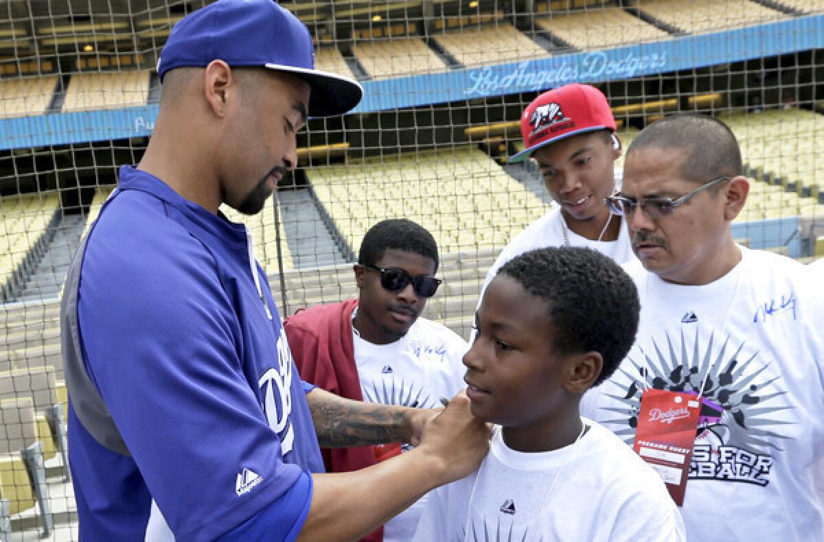 Dodgers center fielder Matt Kemp autographs a fan's shirt before a game against the Cincinnati Reds last month.