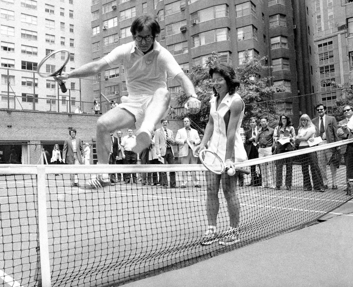 Billie Jean King holds down the net for a jumping Bobby Riggs. The two went head-to-head not only on the court but in the media storm leading up to the match. (MCT)