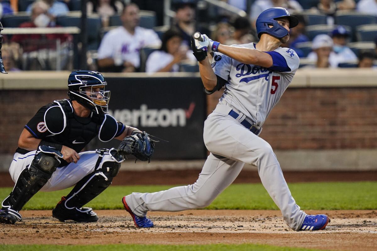 Dodgers' Corey Seager follows through on an RBI double next to New York Mets catcher James McCann.