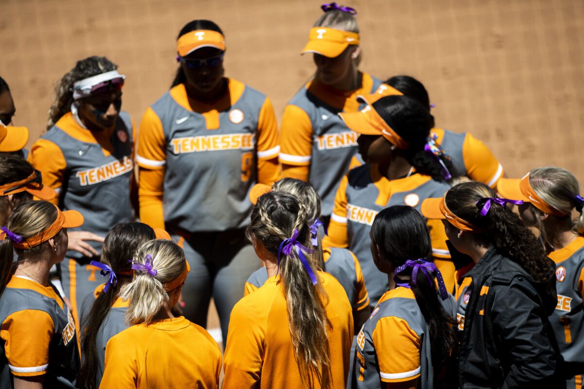 Tennessee softball players wear purple ribbons in their hair during a game against Liberty at Liberty Softball Stadium in Lynchburg, Va. on Wednesday, April 27, 2022 to honor James Madison University softball sophomore catcher Lauren Bernett who recently died. (Kendall Warner/The News & Advance via AP)