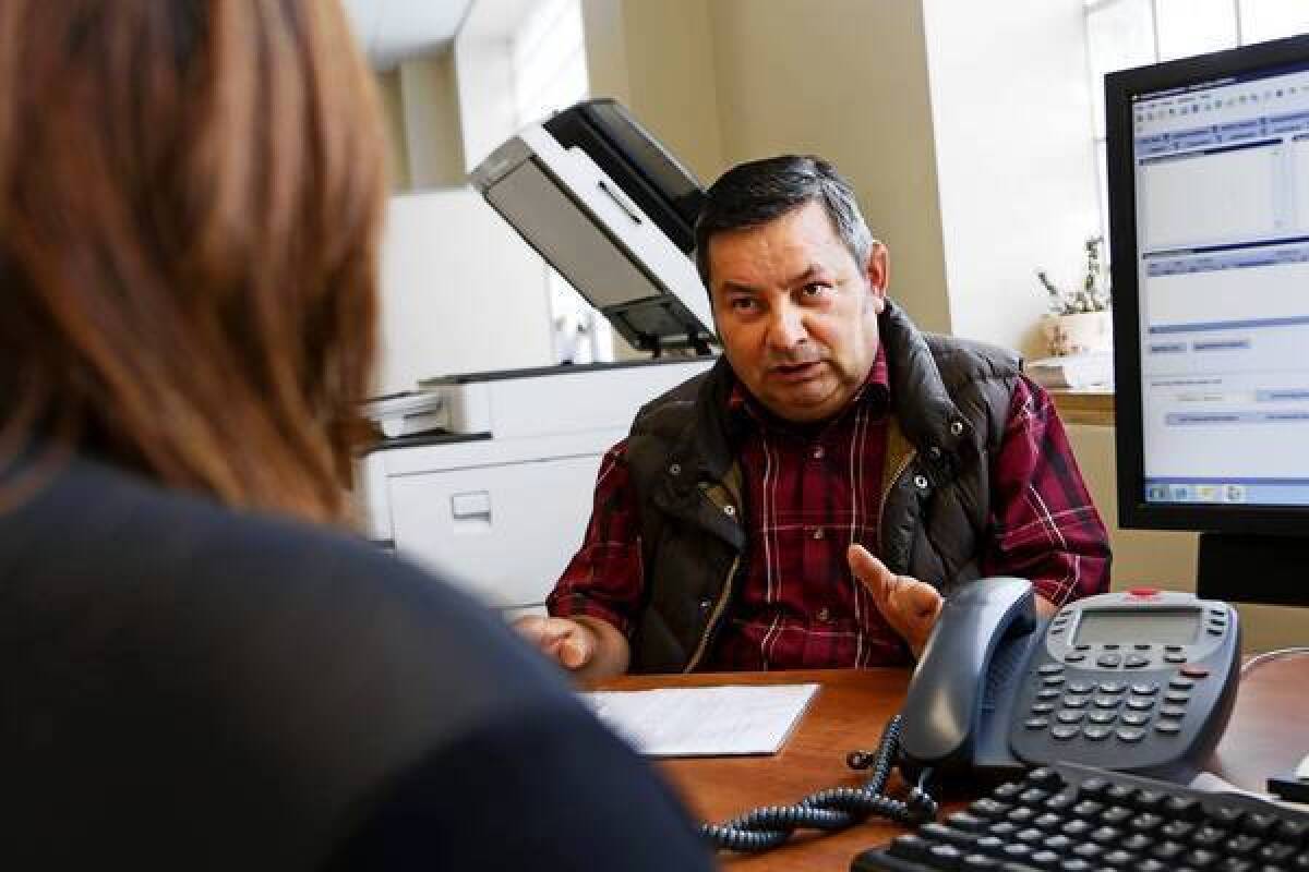 Angel Diaz, right, discusses which forms to fill out to enroll in healthcare coverage with Jessie Orozco at St. John's Well Child & Family Center in South L.A.