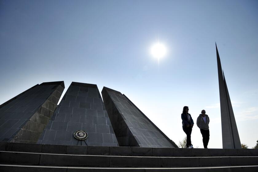 A couple walk at the Tzitzernakaberd memorial to the victims of mass killings by Ottoman Turks, in the Armenian capital Yerevan, Armenia, Wednesday, Oct. 30, 2019. The U.S. House of representatives has voted overwhelmingly to recognize the century-old mass killings of Armenians by Ottoman Turks as genocide. The move is a clear rebuke to NATO ally Turkey in the wake of its invasion of northern Syria. (AP Photo/Hakob Berberyan)