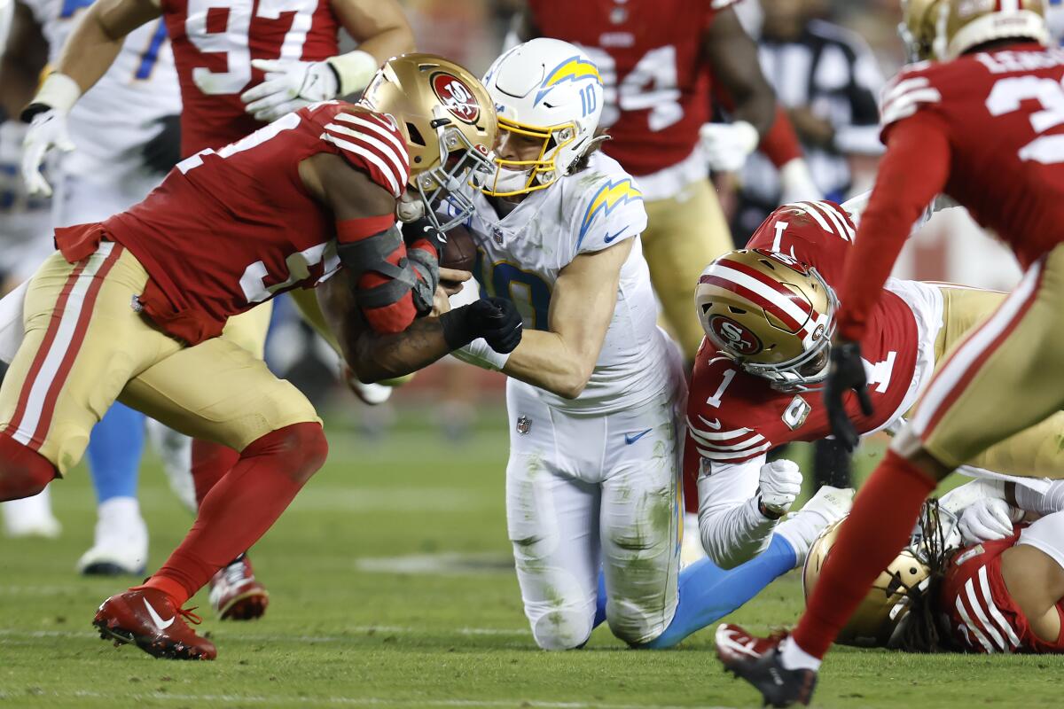 Chargers quarterback Justin Herbert (10) is hit by the 49ers' Dre Greenlaw, who was ejected for a helmet-to-helmet hit. 