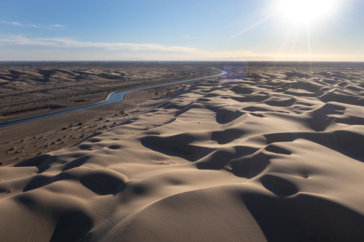 A canal runs between sand dunes.