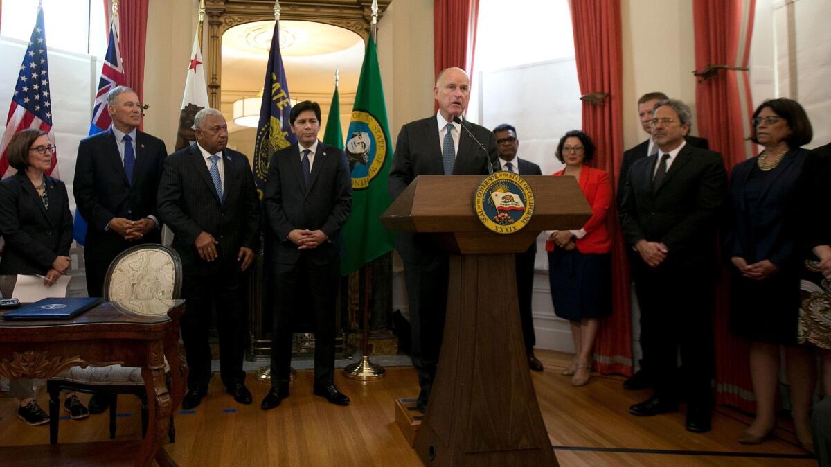 California Gov. Jerry Brown leads a climate change discussion with Fiji Prime Minister Frank Bainimarama, third from left, Oregon Gov. Kate Brown, left, Washington Gov. Jay Inslee, California Senate President Kevin de Leon, fourth from left, and others on June 13, in Sacramento.