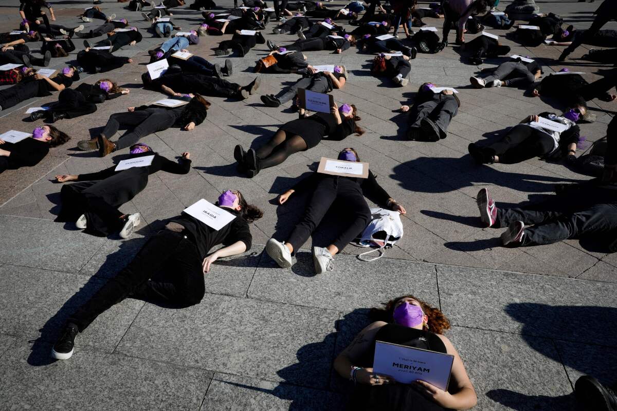 Women wearing black lying on ground in protest