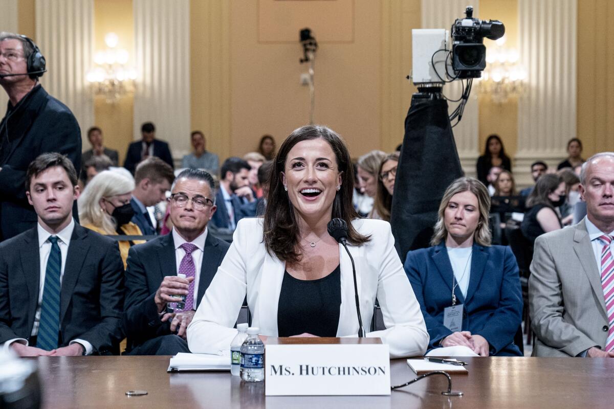 Cassidy Hutchinson, seated behind a name card and a microphone at the witness table 