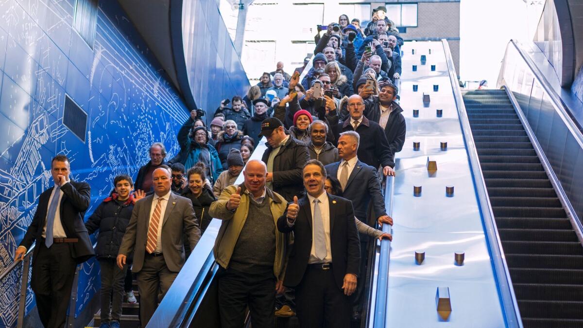 Metropolitan Transportation Authority Chairman and Chief Executive Thomas Prendergast, center left, and New York Gov. Andrew Cuomo, center right, enter the newly opened 96th Street station of the Second Avenue subway along with other riders.
