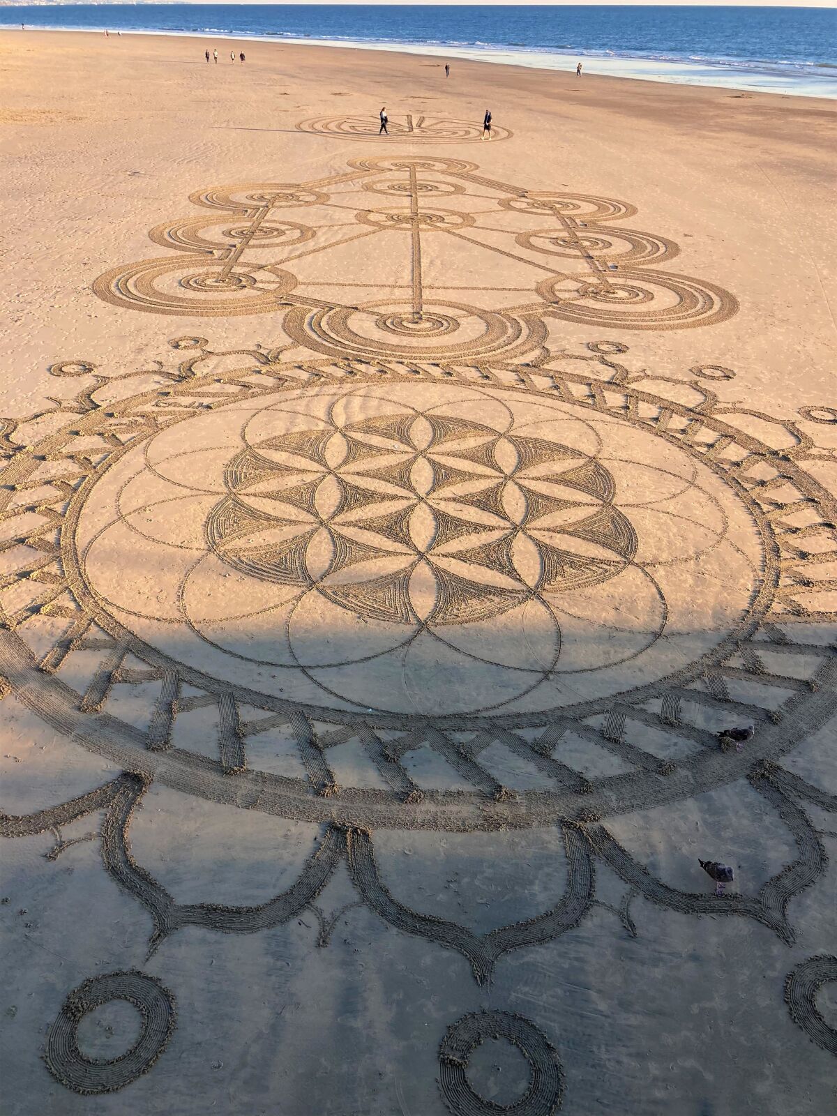A recent geometric sand etching at Newport Beach, created by local artists Shane Kern and Drew Davis, the Low Tide Aliens.
