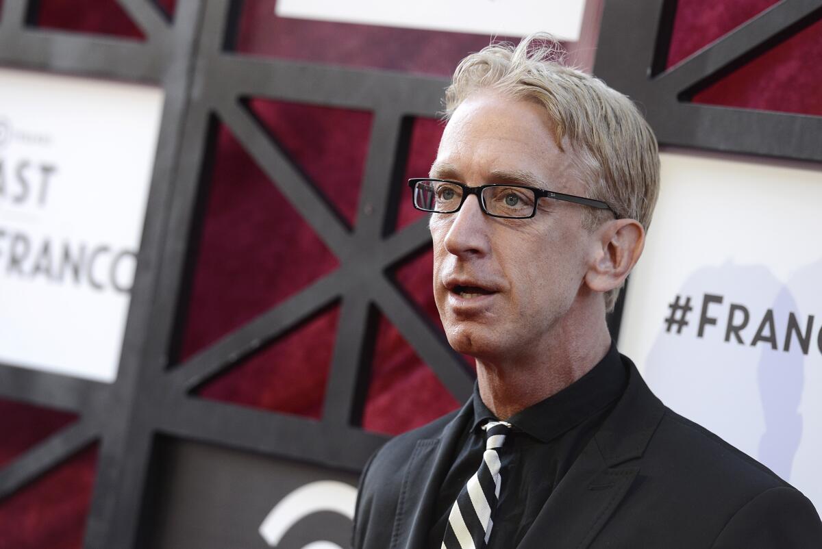 A man wearing glasses and a striped tie with short blond hair