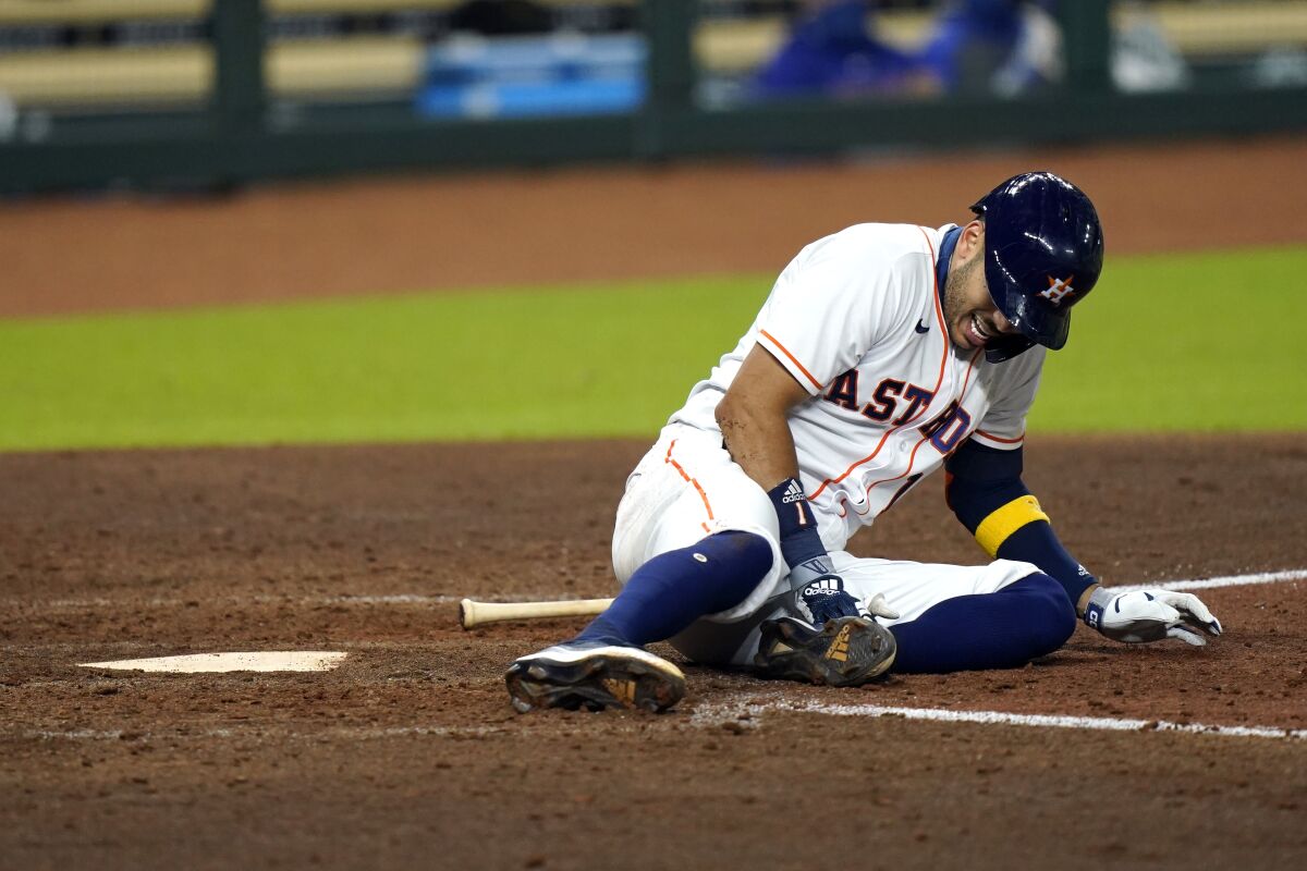 Houston Astros' Carlos Correa reacts after fouling a pitch off his leg during the sixth inning of a baseball game against the Texas Rangers Tuesday, Sept. 15, 2020, in Houston. Correa left the game after the injury. (AP Photo/David J. Phillip)