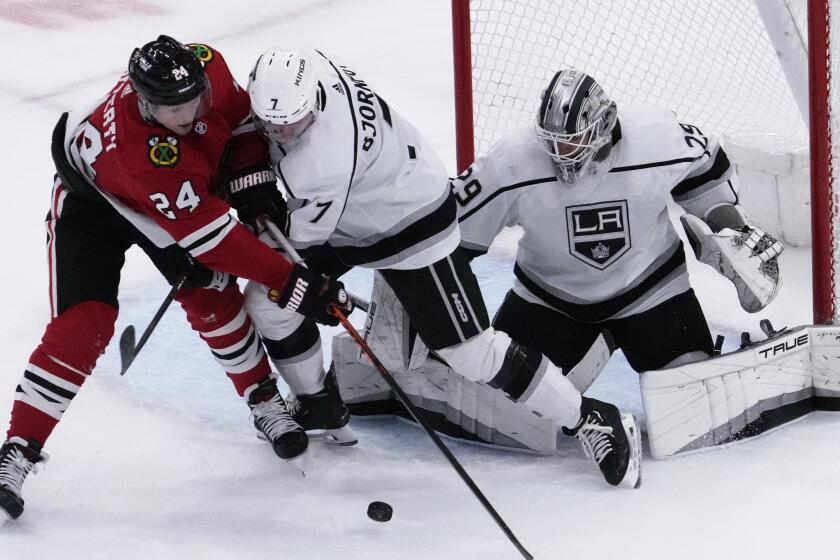 Chicago Blackhawks center Sam Lafferty, battles for the puck against Los Angeles Kings defenseman.