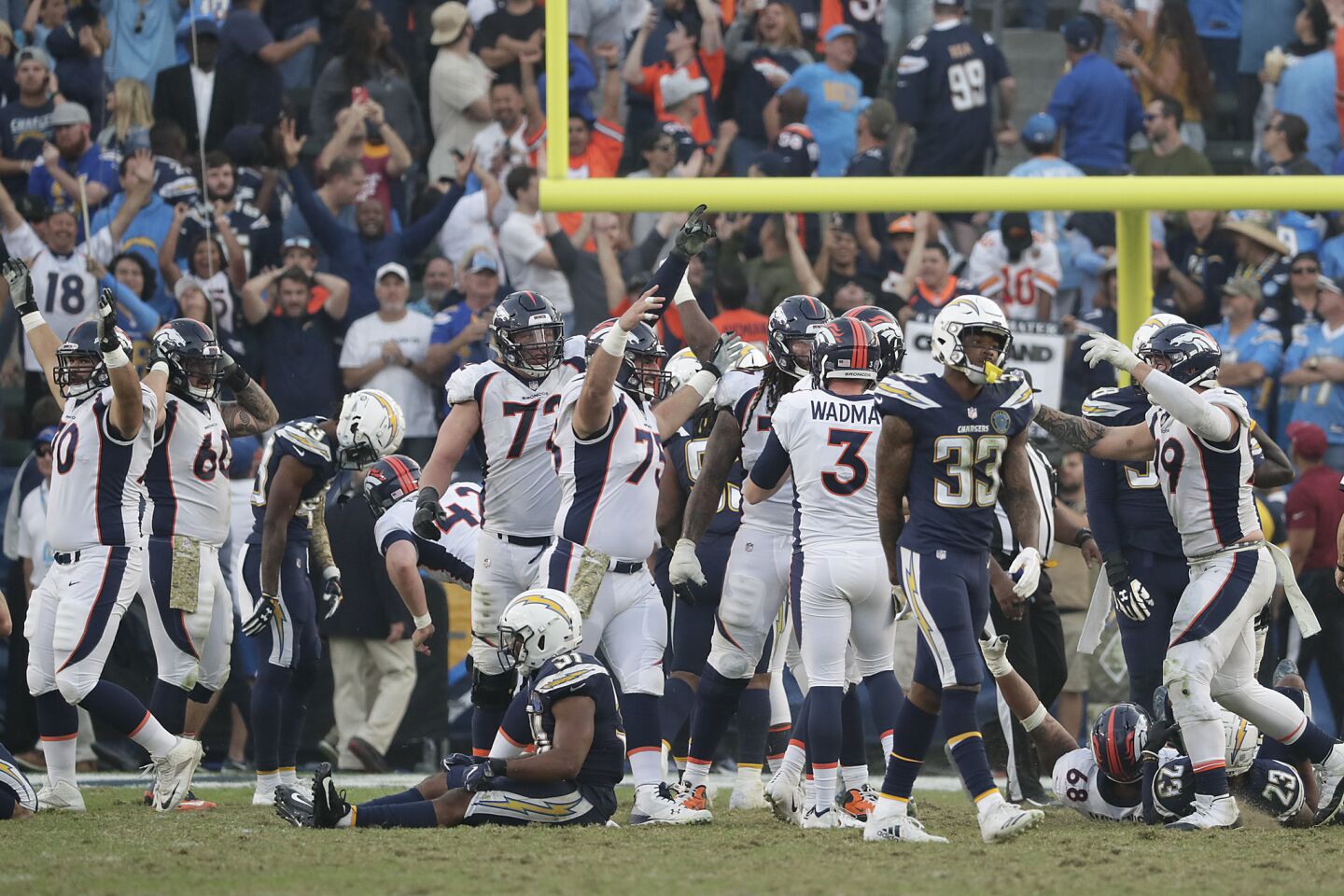 Chargers safeties Adrian Phillips, left, and Derwin James walk away in defeat after Denver Broncos kicker Brandon McManus kicked a 34-yard field goal for a 23-22 win at Stubhub Center.