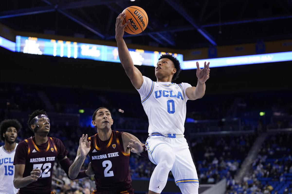 UCLA guard Jaylen Clark, center, drives past Arizona State forward Jalen Graham.