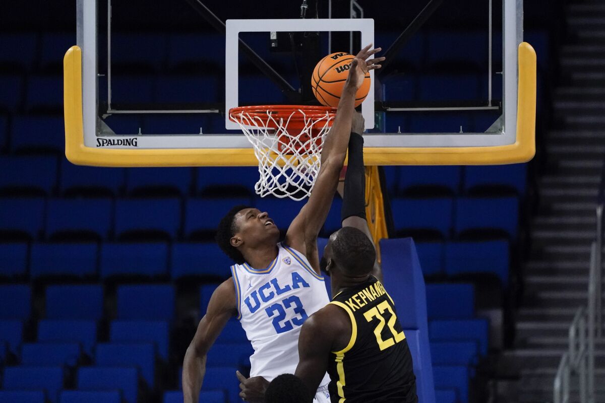 Oregon center Franck Kepnang shoots against UCLA guard Peyton Watson.