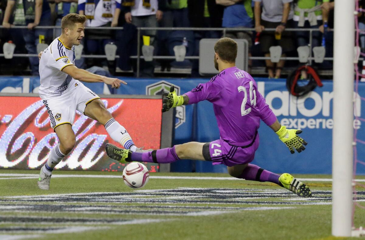 Los Angeles Galaxy midfielder Robbie Rogers, left, tries to get a shot past Seattle Sounders goalkeeper Stefan Frei, right, in the first half of an MLS soccer match, Sunday, Oct. 4, 2015, in Seattle. (AP Photo/Ted S. Warren)