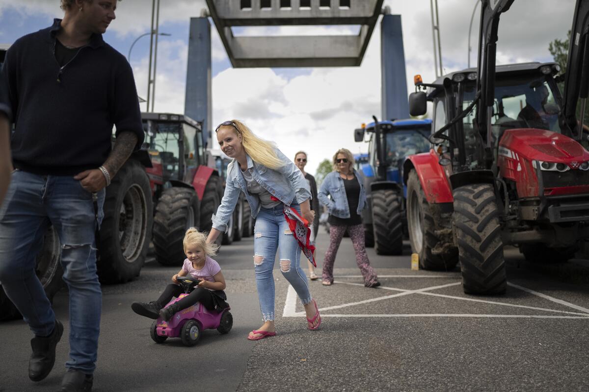 Protesting farmers block a drawbridge at locks in the Princess Margriet canal, preventing all ship traffic from passing in Gaarkeuken, northern Netherlands, Monday, July 4, 2022. Dutch farmers angry at government plans to slash emissions also used tractors and trucks Monday to blockade supermarket distribution centers, the latest actions in a summer of discontent in the country's lucrative agricultural sector. (AP Photo/Peter Dejong)