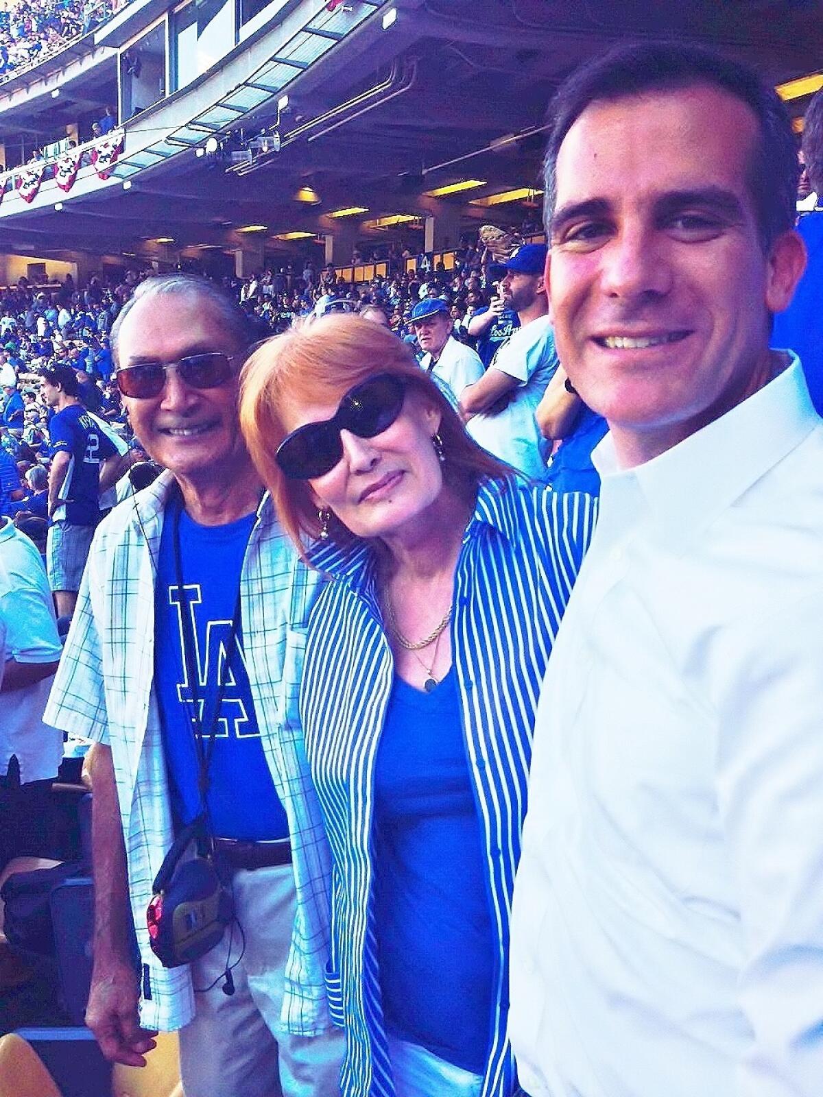 Suzanne Lewis poses with her father, Louis Avila, and L.A. Mayor Eric Garcetti at a Dodgers game in 2015.