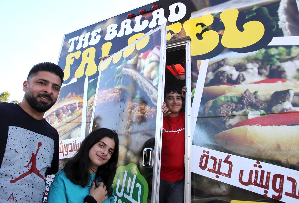 Sanad Morra, co-owner of Balad Falafel, left, poses with his children, Zaina and Mahmoud.