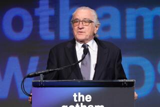 Robert De Niro speaks behind a lectern while wearing a suit at the 2023 Gotham Awards