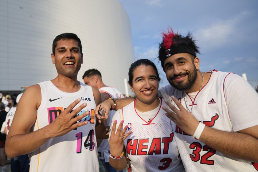 Rishabh Goel, left, and siblings Karishma, center, and Sid Chadha, Miami Heat fans from New Jersey, wait to enter the arena for Game 3 of the NBA Finals basketball game against the Denver Nuggets, Wednesday, June 7, 2023, in Miami. (AP Photo/Rebecca Blackwell)