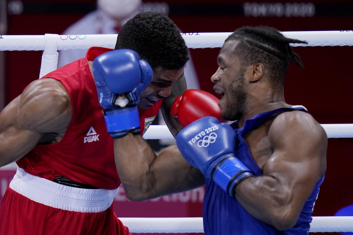 Brazil's Abner Teixeira, left, exchanges punches with Britain's Cheavon Clarke.