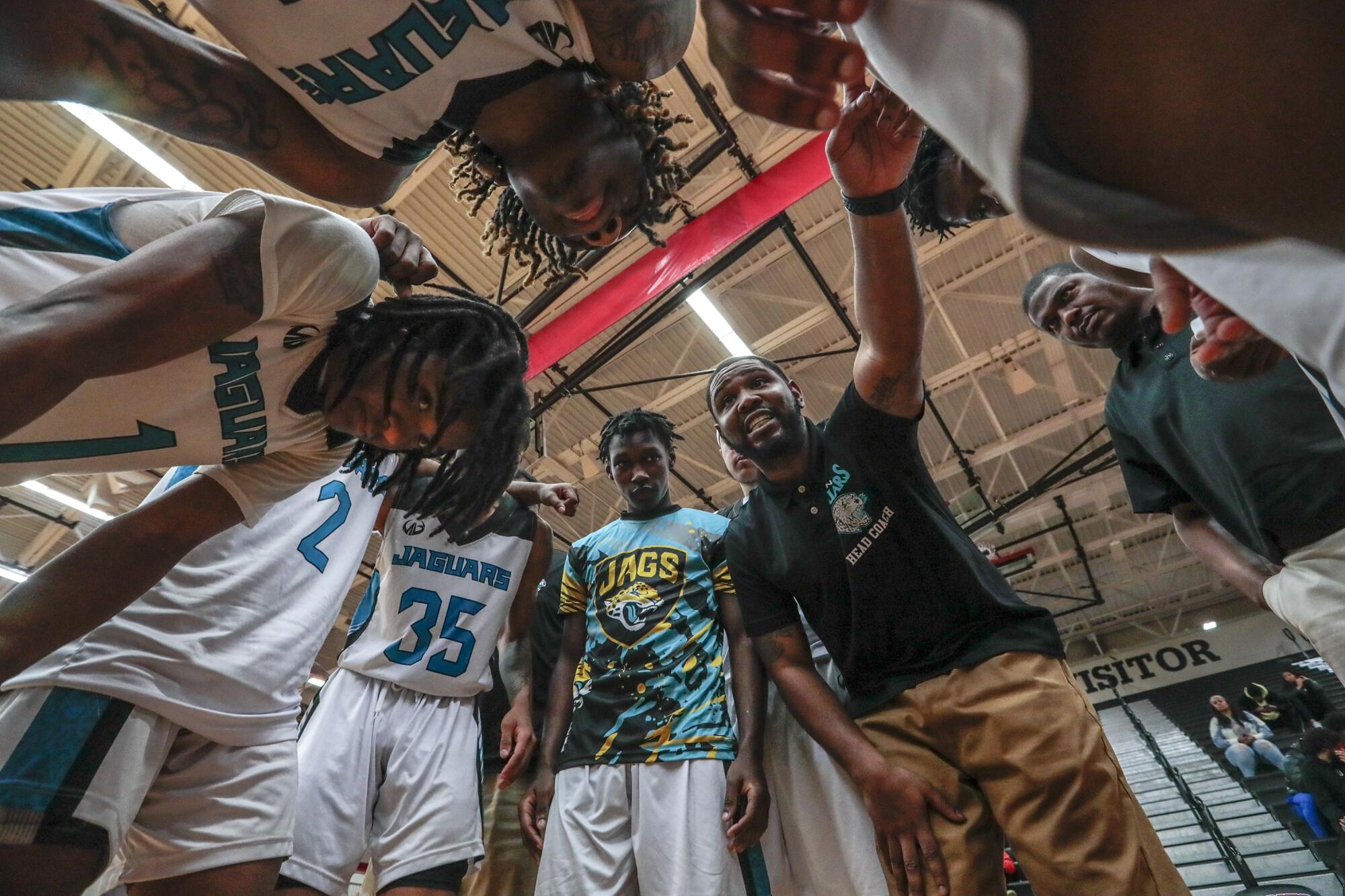 Flint coach Demarkus Jackson talks to his players during a game timeout.