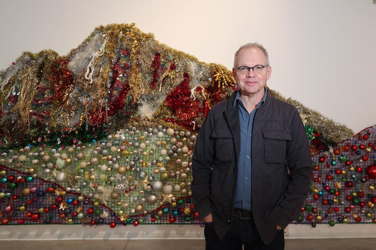 Tyler Stallings stands next to a collection of Christmas decorations made in the impression of Spirit Mountain.